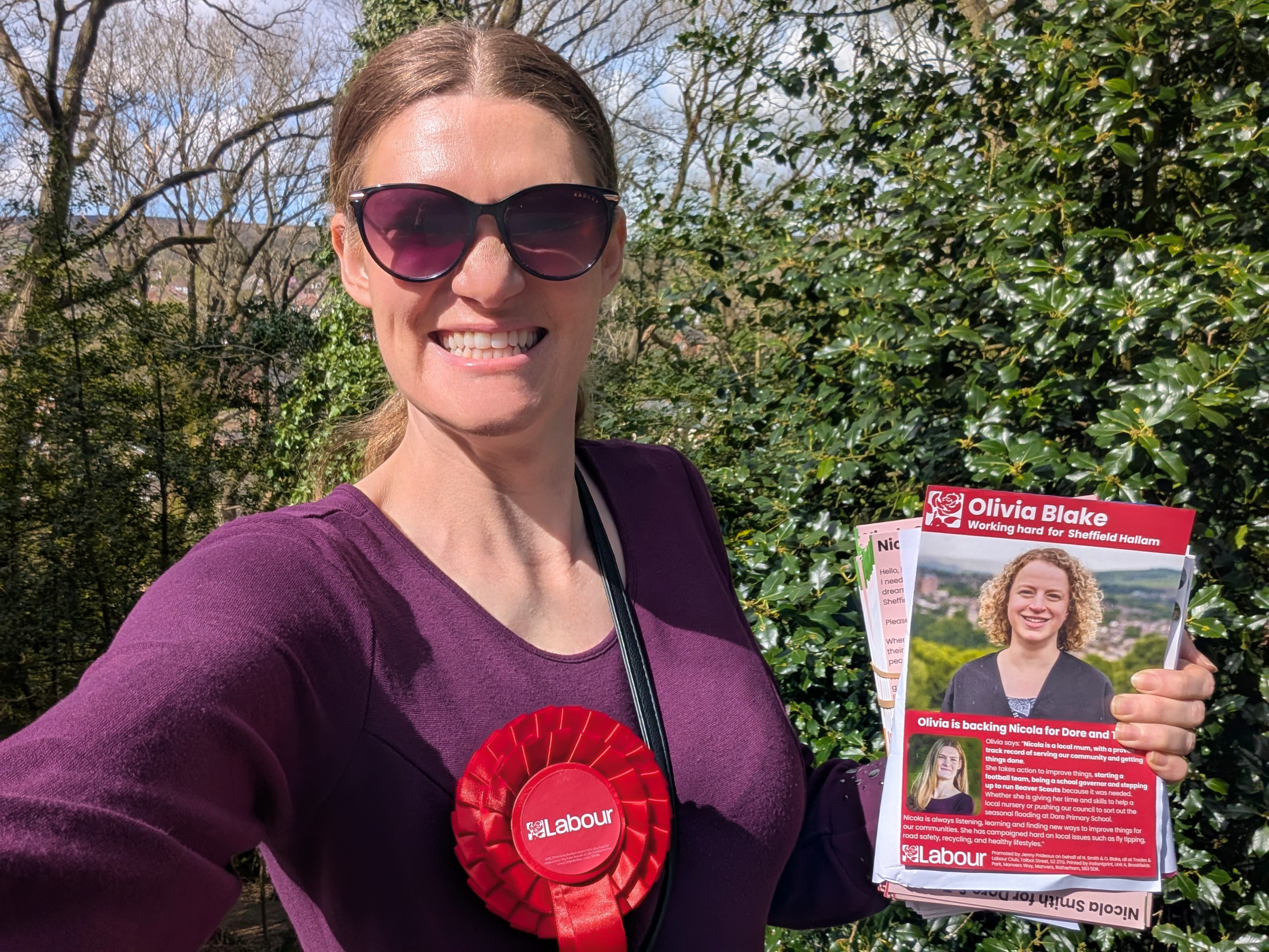Nicola Smith holding her leaflet in a purple dress